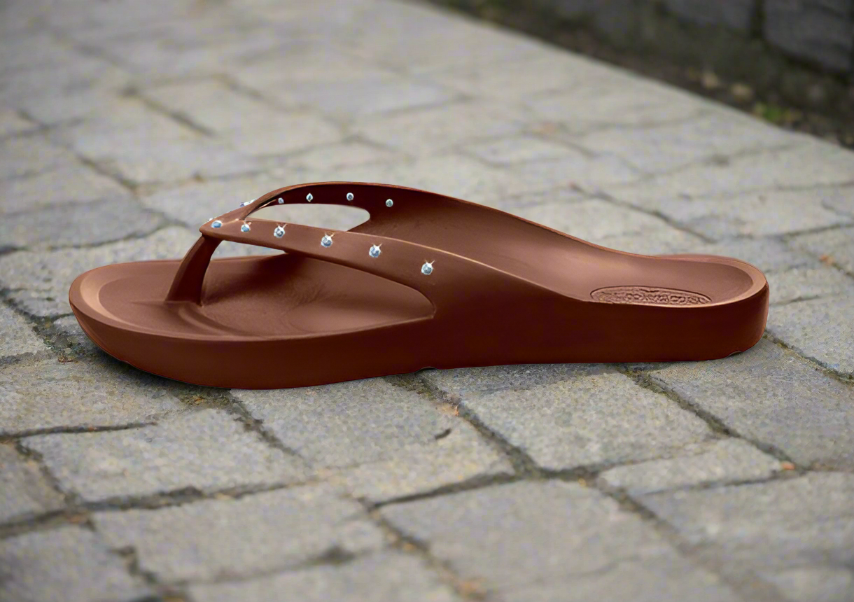 flopeds princess Brown sandal with decorative elements on a stone pavement